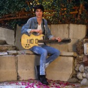 Portrait of American Rock musician Dwight Twilley as he holds a 12-string Carvin guitar, seated in his garden, Los Angeles, California, 1984. (Photo by John Kisch Archive/Getty Images)
